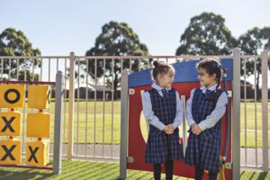 Children chatting in front of new play equipment